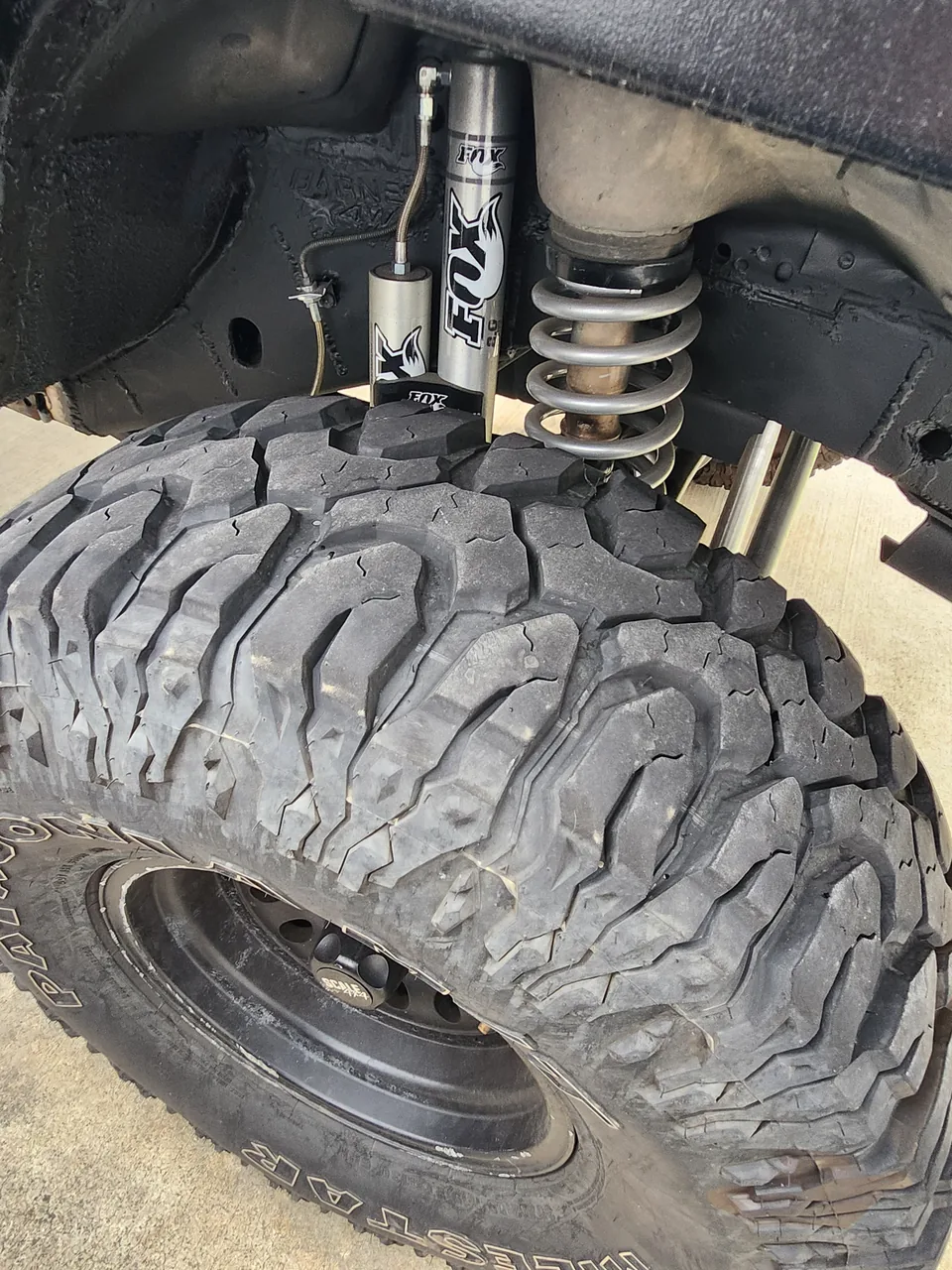 Fox shock behind a mud terrain tire on a lifted 4x4