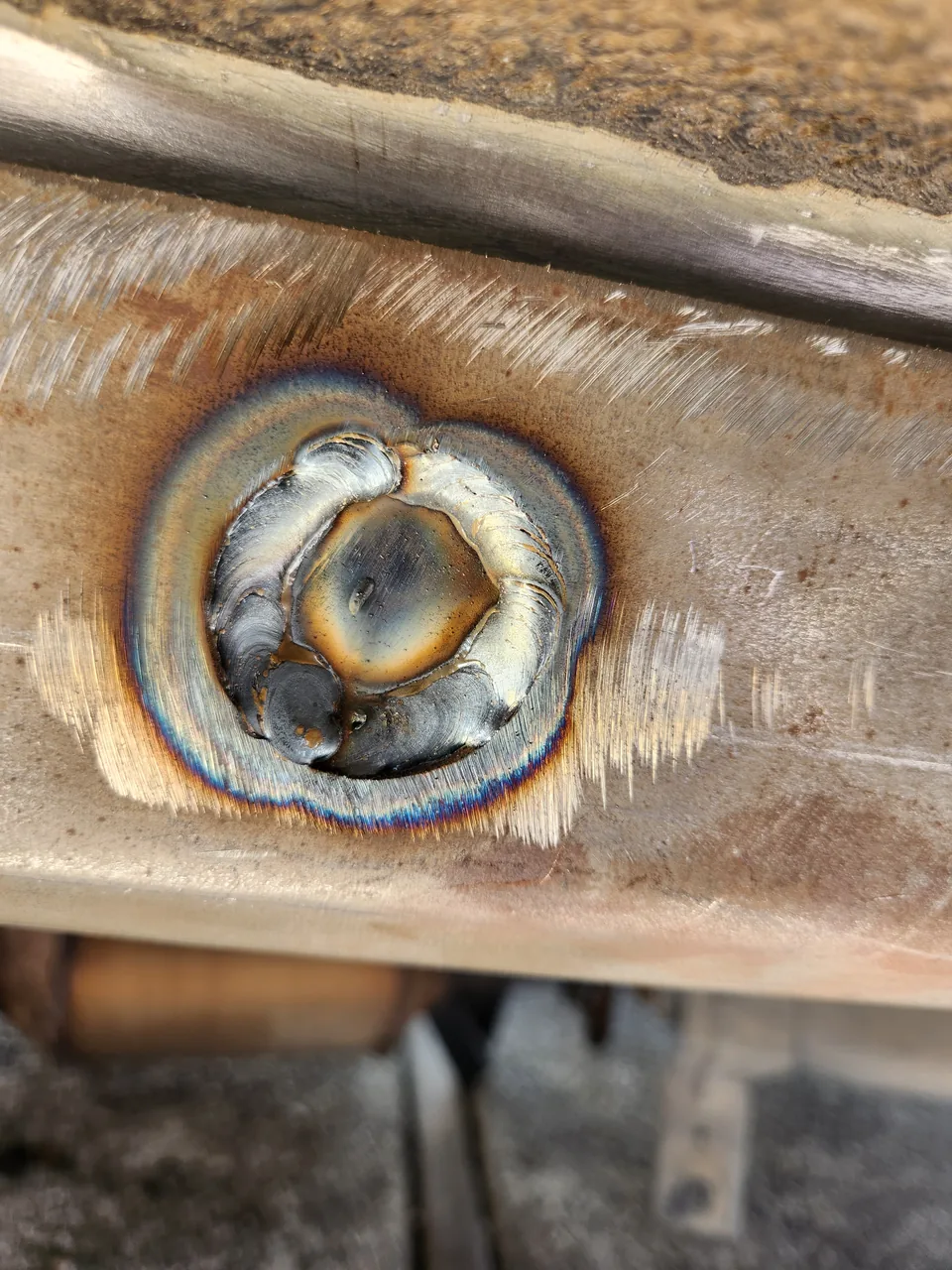 Close-up of a fresh weld repairing a vehicle frame
