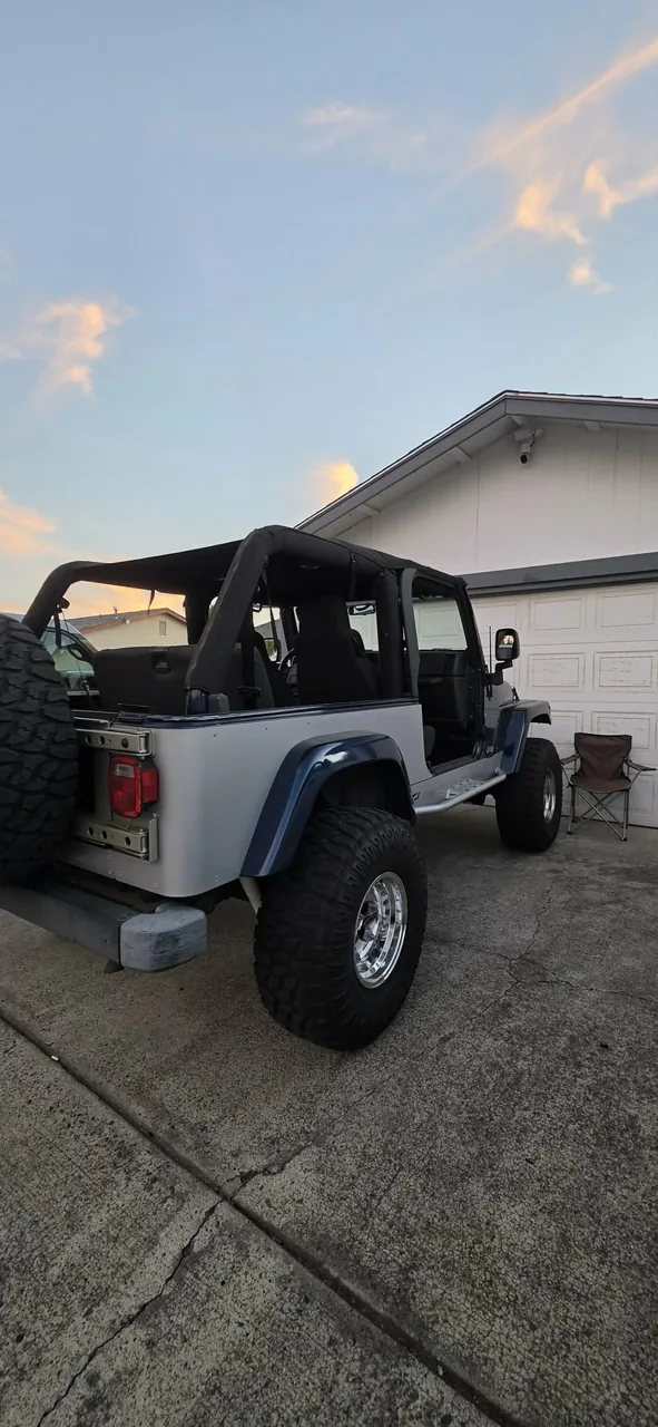 Silver Jeep Wrangler with lift kit and larger tires