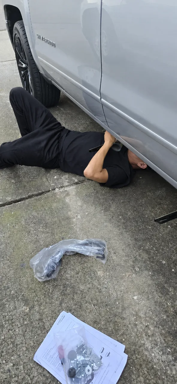 Mechanic working underneath a van at the customer's home